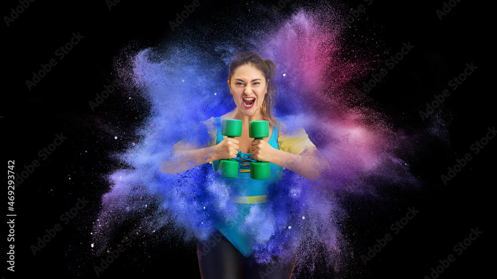 Collage with young female athlete, fitness coach posing in explosion of colored neon powder isolated on dark background