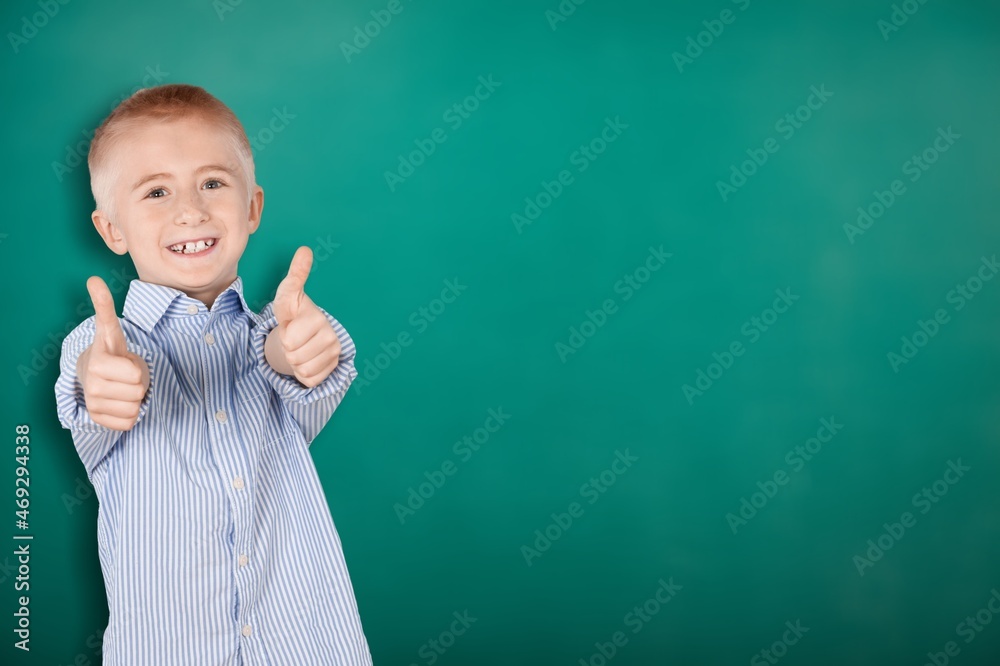 Ð¡heerful happy young small boy make fingers thumbs up smile recommend