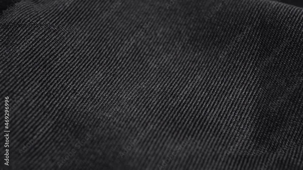 Textured black grunge textile material. Macro. Slow rotation. Abstract texture