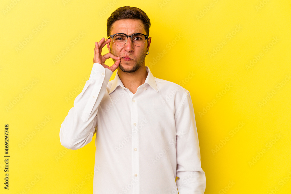 Young caucasian man with tattoos isolated on yellow background with fingers on lips keeping a secret. Young caucasian man with tattoos isolated on yellow background with fingers on lips keeping a secret.