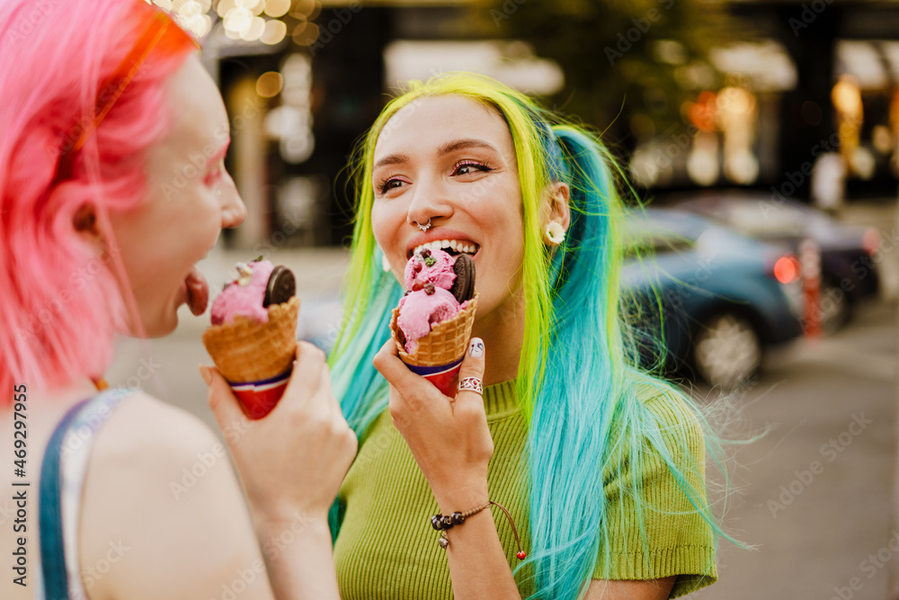 Young lesbian couple smiling while eating ice cream together