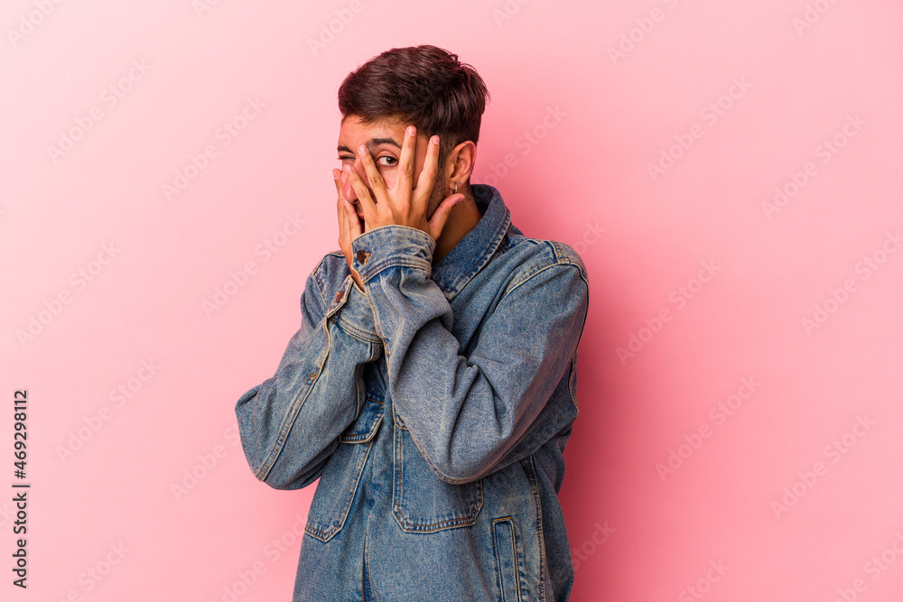 Young caucasian man with tattoos isolated on yellow background blink through fingers frightened and nervous. Young caucasian man with tattoos isolated on yellow background blink through fingers frightened and nervous.