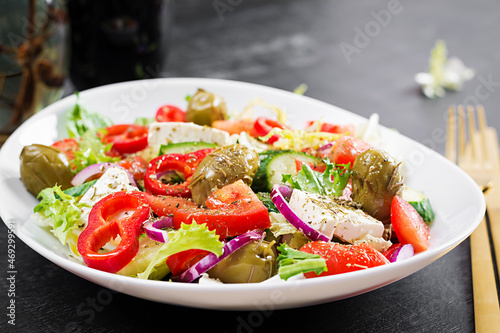 Greek salad of fresh  tomato, sweet pepper, cucumber, red onion, feta cheese and green olives. Healthy vegetarian food.