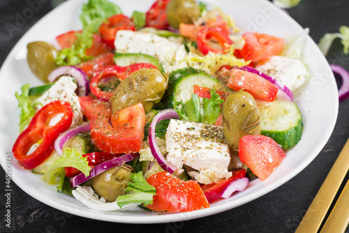 Greek salad of fresh tomato, sweet pepper, cucumber, red onion, feta cheese and green olives. Healthy vegetarian food.