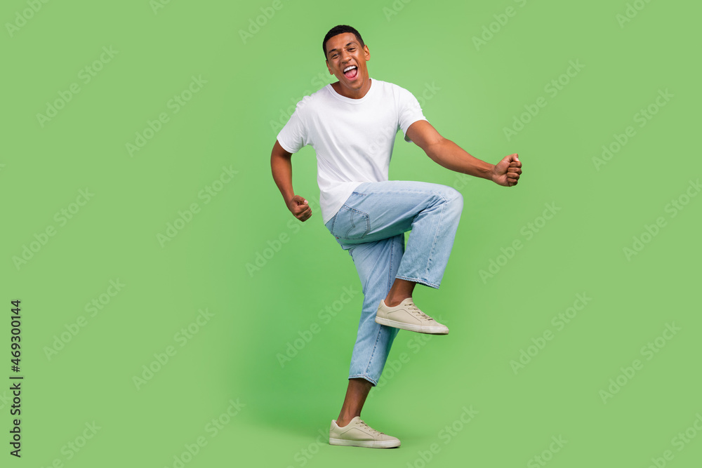 Full size profile side photo of young excited afro guy good mood rejoice victory isolated over green color background Full size profile side photo of young excited afro guy good mood rejoice victory isolated over green color background