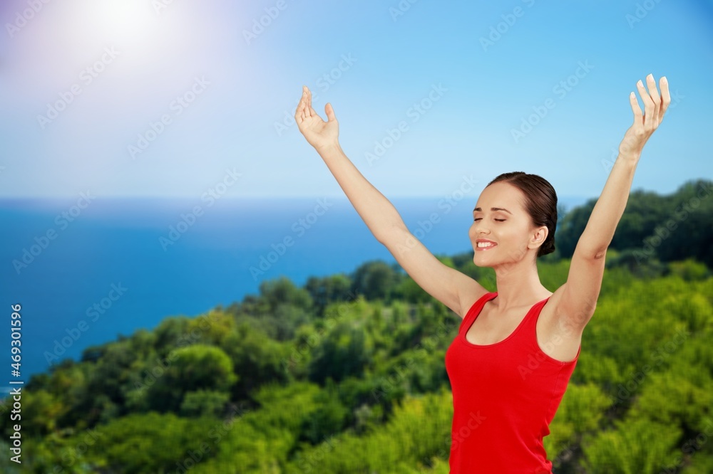 Woman raised hands up on top of mountain and sunset background. Freedom, Pray,
