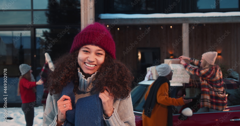 Excited happy attractive young mixed race woman in winter hat smiling at camera at fun Christmas party slow motion.
