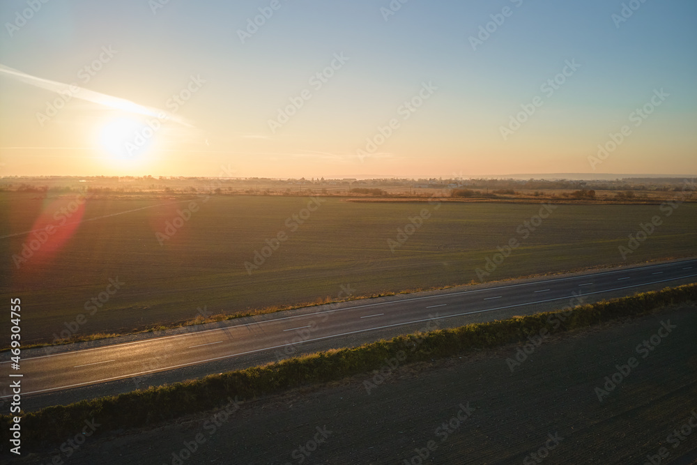 Aerial view of empty intercity road at sunset. Top view from drone of highway in evening