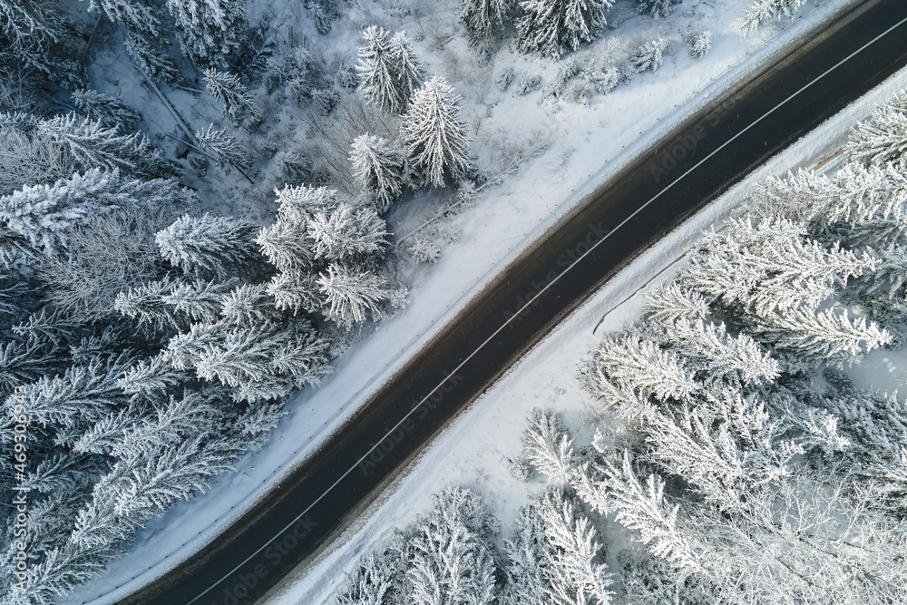 Aerial view of winter landscape with snow covered mountain woods and winding forest slippery road Aerial view of winter landscape with snow covered mountain woods and winding forest slippery road