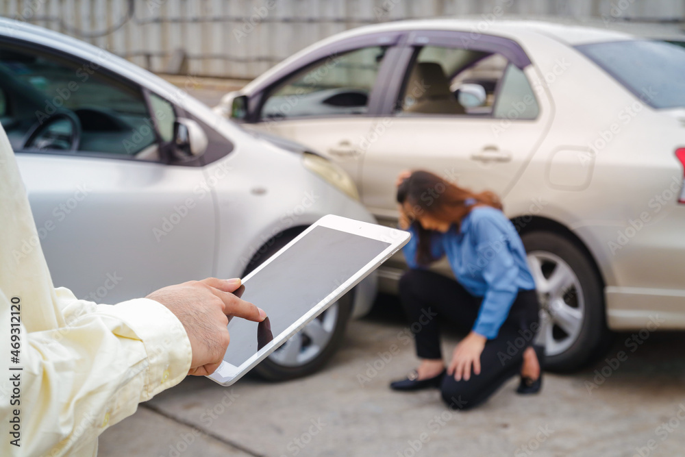 insurance company employee Saving insurance claim information on the tablet. The woman was sad that the car was hit. car insurance concept
