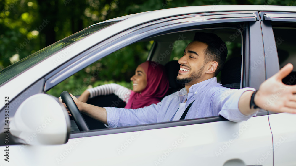 Happy Owners. Cheerful Middle Eastern Couple Enjoying Ride In Their New Car