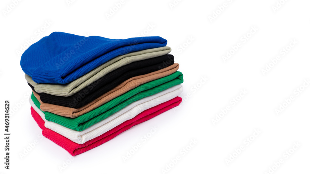Stack of insulated stylish beanie hats in bright colors isolated on white with copy space. Stack of insulated stylish beanie hats in bright colors isolated on white with copy space.