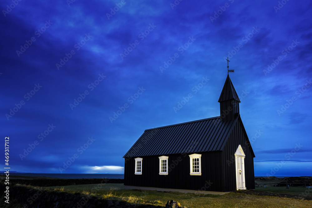Budir Black Church, Snaefellsnes peninsula, Iceland. Blue hour shot of the illuminated wooden church, just before daybreak.