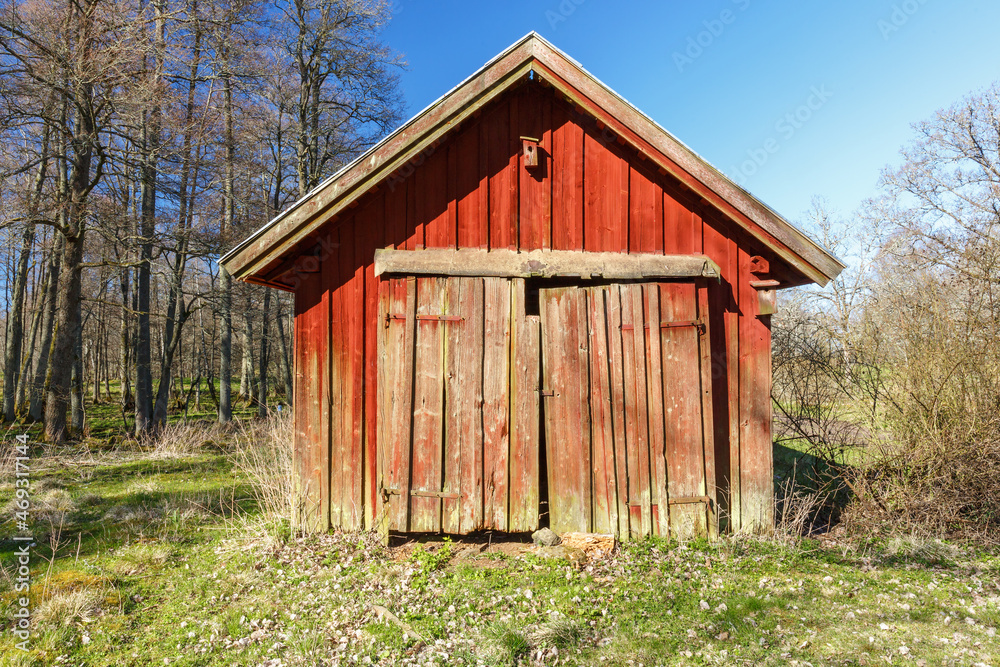 Fototapeta premium Old red wooden shed with crooked doors