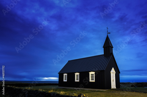 Budir Black Church, Snaefellsnes peninsula, Iceland. Blue hour shot of the illuminated wooden church, just before daybreak.