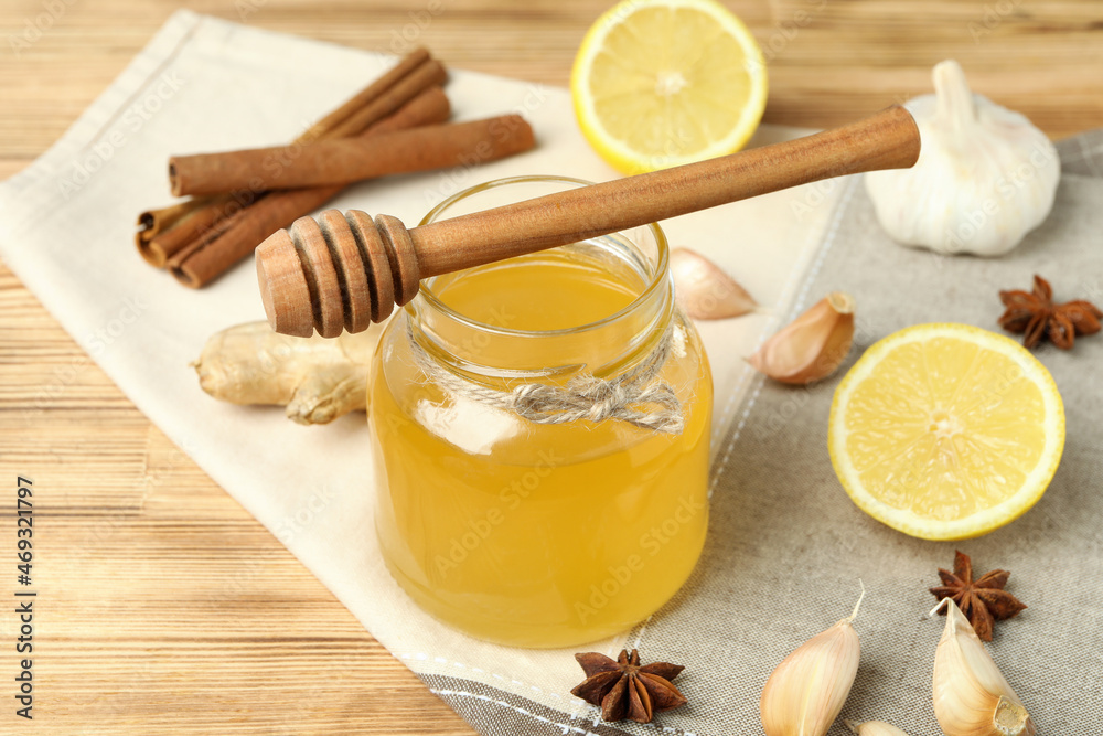 Concept of treatment colds with honey and garlic on wooden background Concept of treatment colds with honey and garlic on wooden background