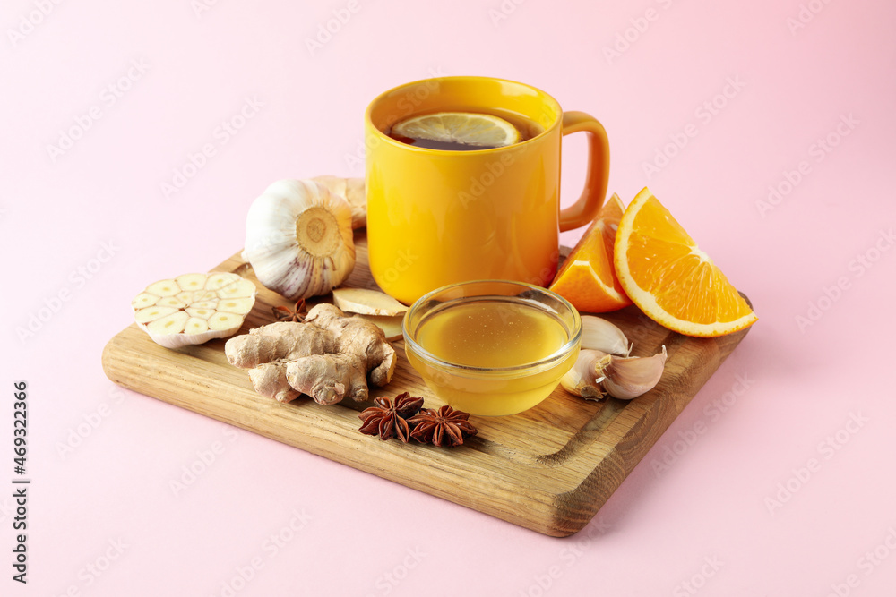 Concept of treatment colds with honey and garlic on pink background Concept of treatment colds with honey and garlic on pink background