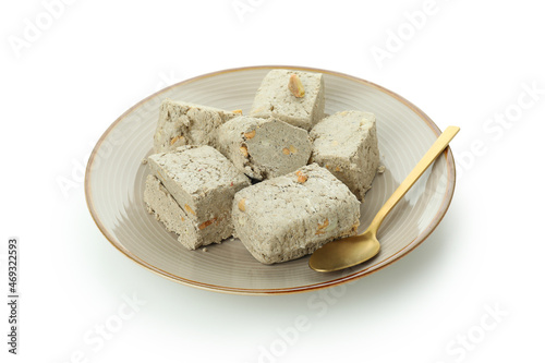 Plate with halva and spoon isolated on white background photo