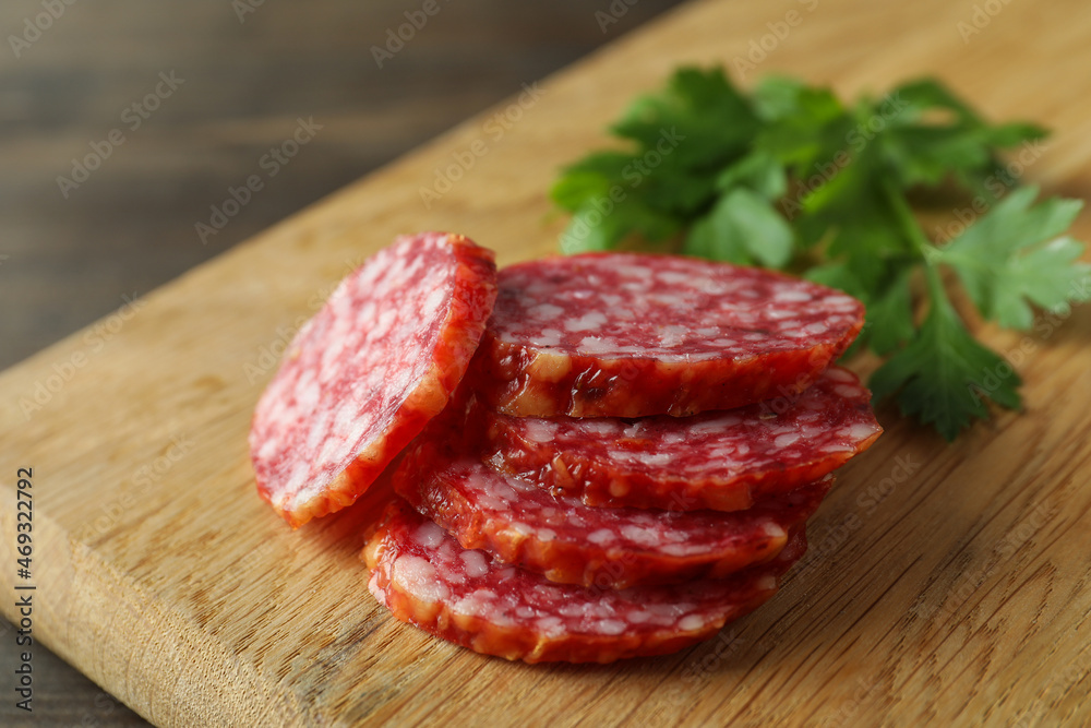 Сoncept of tasty food with salami sausage on wooden background Сoncept of tasty food with salami sausage on wooden background