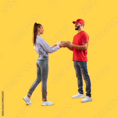 Male Courier Giving Parcel Box To Customer Woman, Yellow Background