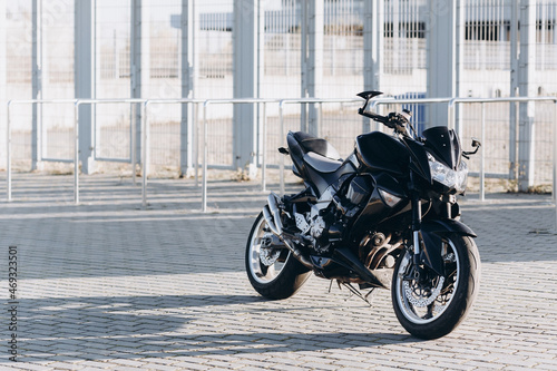 a black sports motorcycle parked near a modern underground stadium