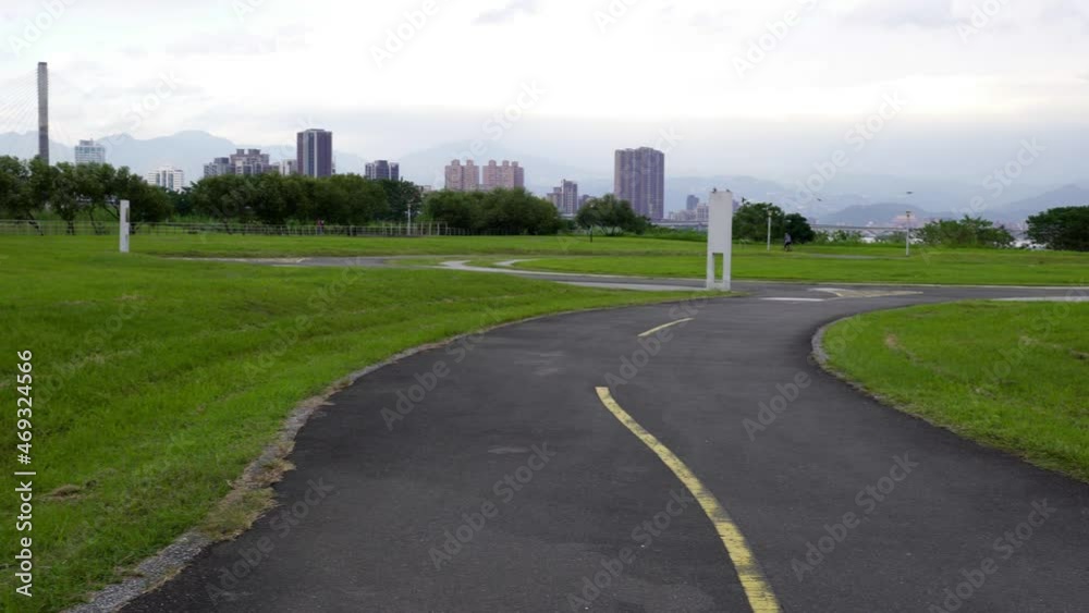 Bicycle trail with grass. The background scenery is buildings, bridges and sky. Bicycle trail with grass. The background scenery is buildings, bridges and sky.