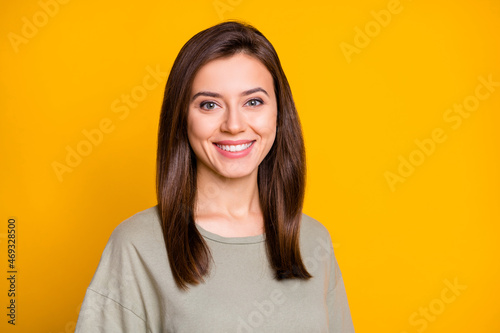 Photo of young lovely pretty good mood smiling cheerful happy girl with silky brown hair isolated on yellow color background