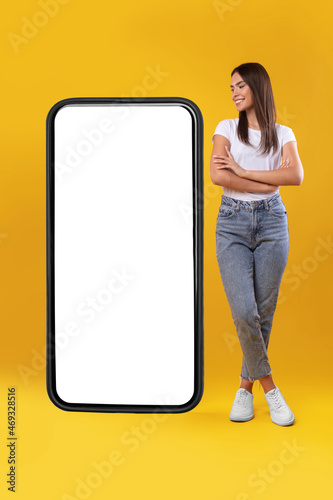 Woman standing near big empty smartphone screen with crossed hands