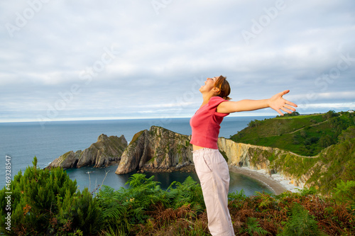Excited woman outstretching arms screaming on the beach