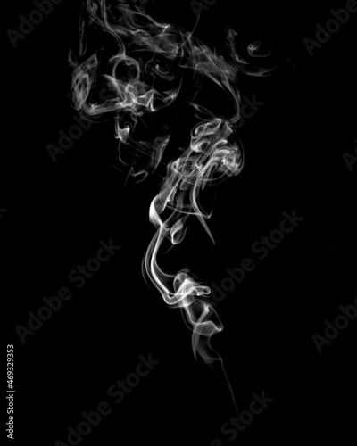 Abstract white smoke on black background. Vertical monochrome, grayscale photography of illuminated incense. Moody feeling. Dark backdrop, graphic resource for montage, overlay or texture, copy space.