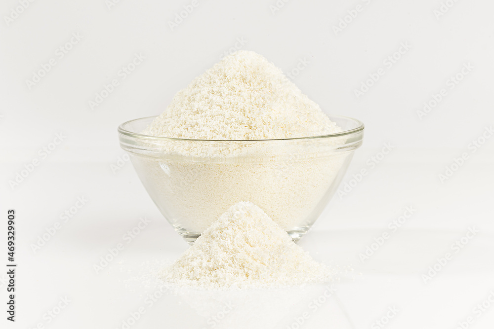 Grounded coconut flakes in a glass bowl, coconut isolated on white background Grounded coconut flakes in a glass bowl, coconut isolated on white background