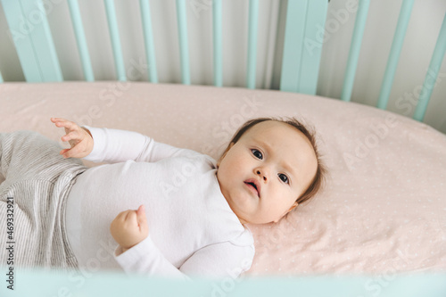 Adorable Baby Girl Lying Inside Crib