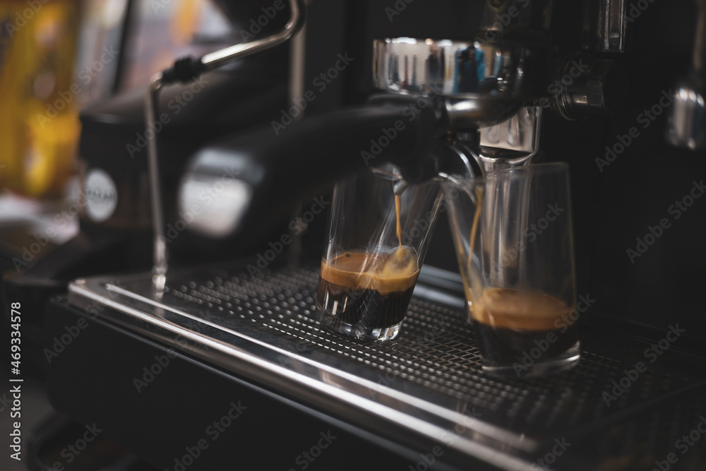 a coffee-making machine preparing two glasses. a coffee-making machine preparing two glasses.