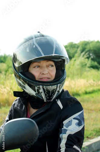 Woman biker in a safety helmet and special protective clothing for riding a motorcycle. © natavilman