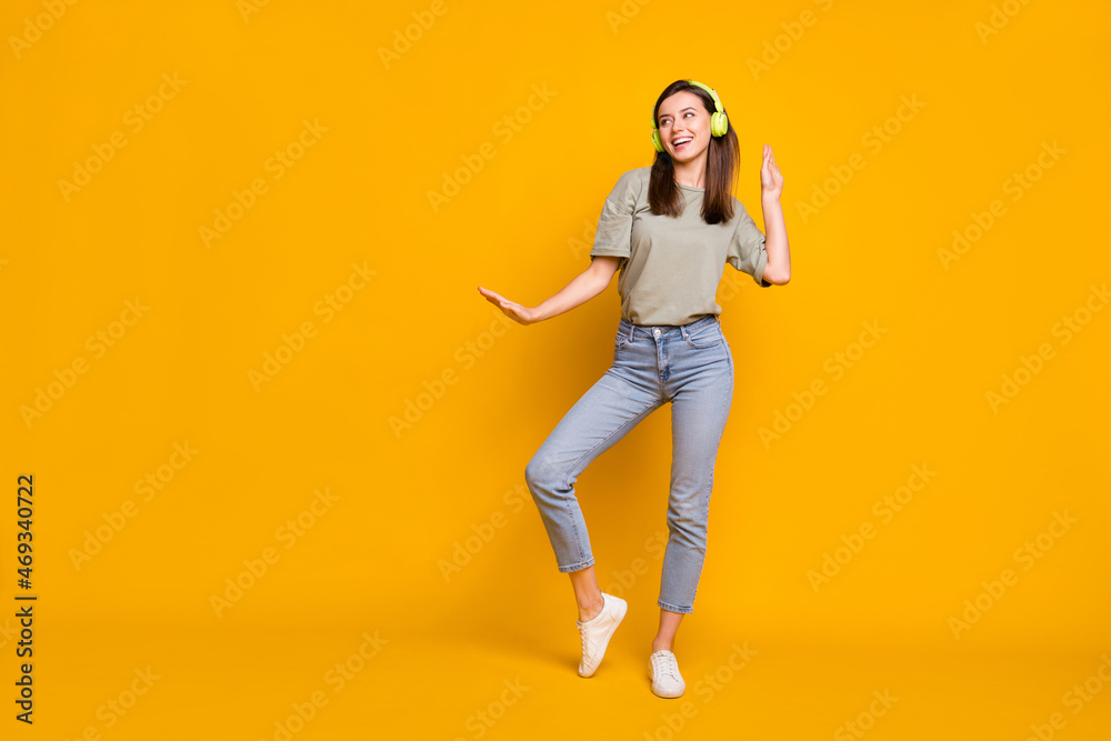 Full length body size view of pretty carefree cheerful girl listening melody dancing rest isolated over bright yellow color background