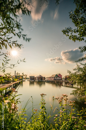 Houses in the lake in Hungary. with a long jetty or pier that goes into the lake, where the holiday homes are
