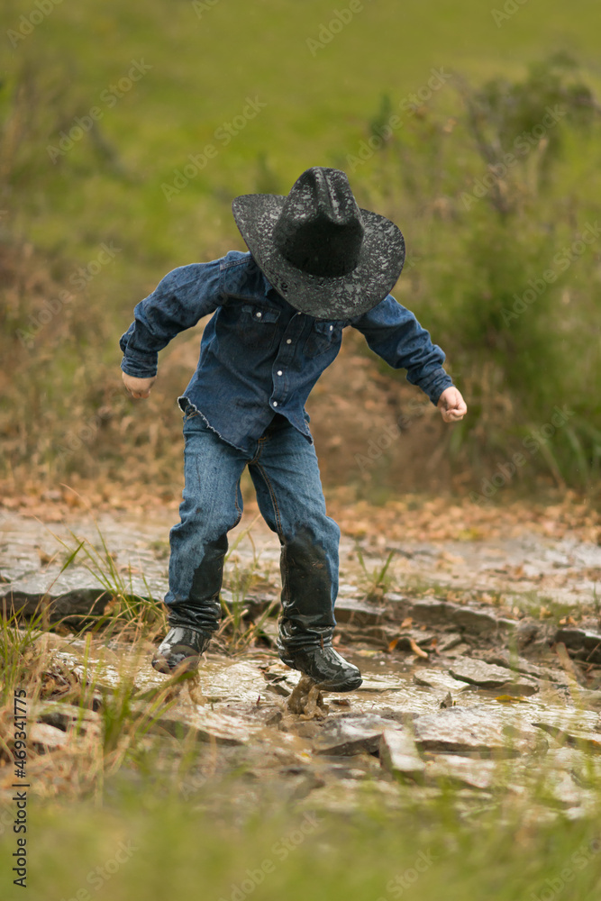 Boy Cowboy Outside Jumping In Puddle Cowboy Hat Jeans Boy Jump Explore Carefree Not a Care in the World Fun 