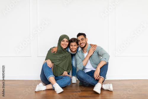 Happy muslim man, woman and girl looking at camera