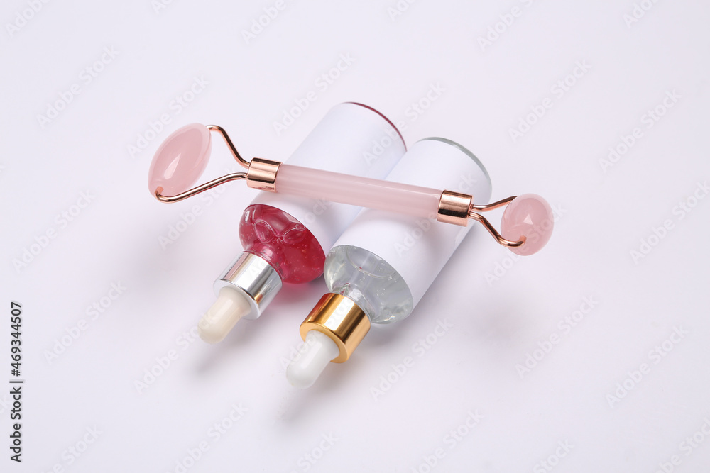Beautiful composition of mockup serum bottles, pink face roller on white background. Creative trendy beauty layout