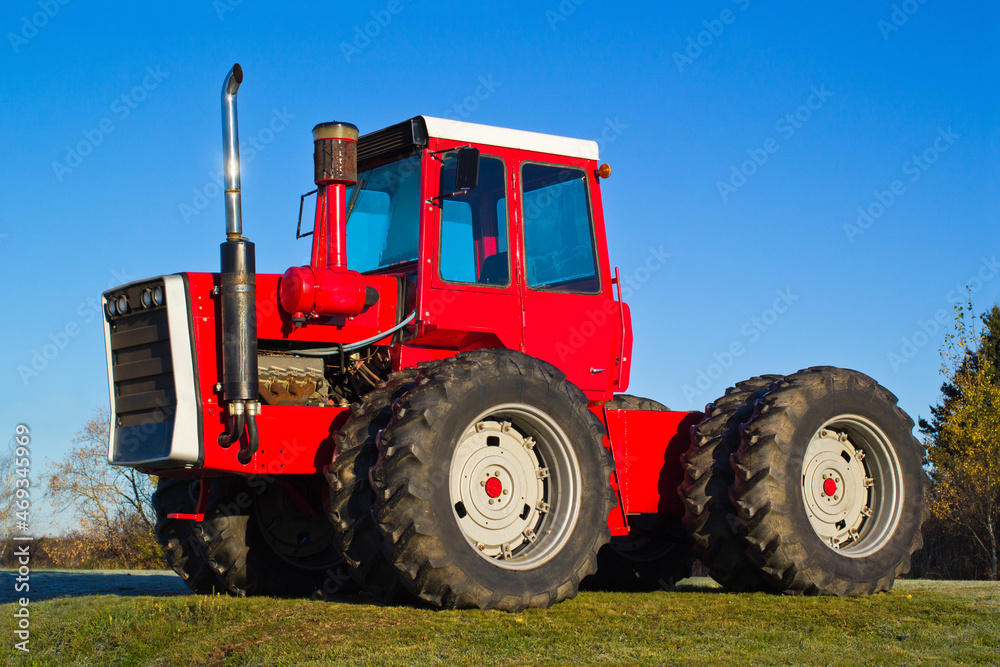 Red four-wheel drive farm tractor and blue sky Red four-wheel drive farm tractor and blue sky