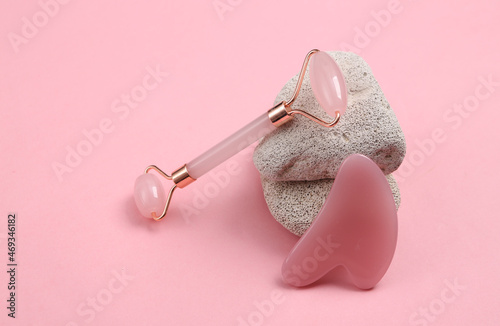 Facial massage roller with natural stone on pink background