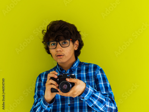 Canvas Print Enthusiastic arab teen photographer with analog slr camera on green background