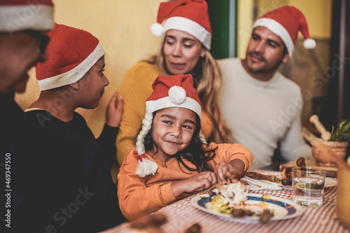 Happy latin family celebrating christmas at home and eating dinner together