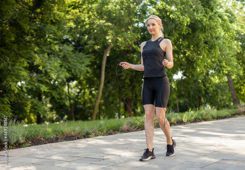 Young fit woman holding a skipping rope in the park © splitov27
