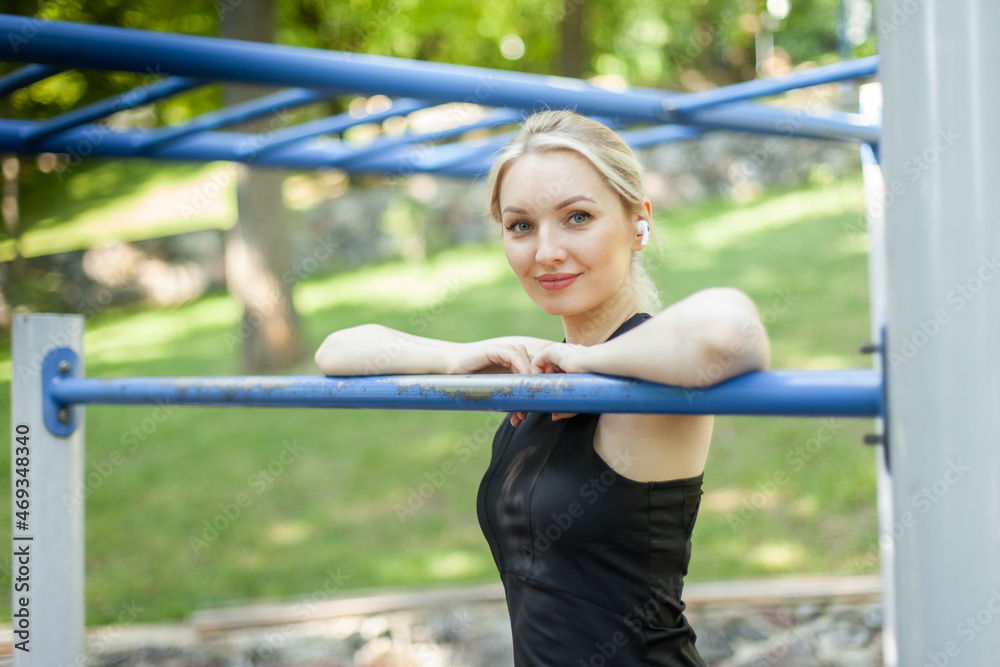 Fototapeta premium Portrait of a cute blonde woman on a workout ground