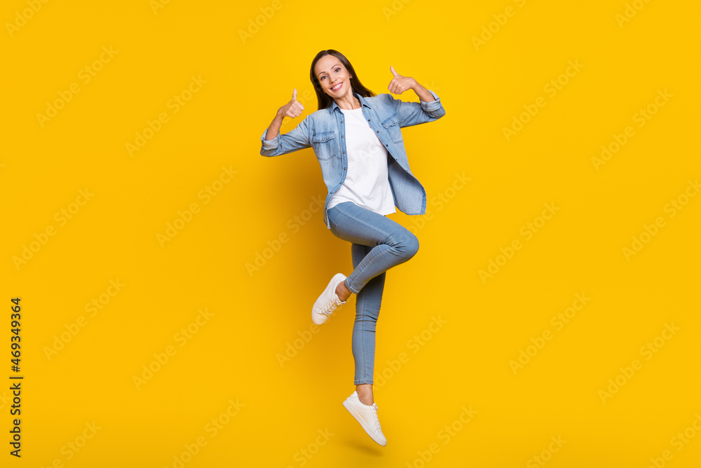 Full length photo of young woman jump up show thumbs-up ads decision feedback isolated over yellow color background