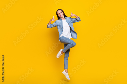 Full length photo of young woman jump up show thumbs-up ads decision feedback isolated over yellow color background © deagreez