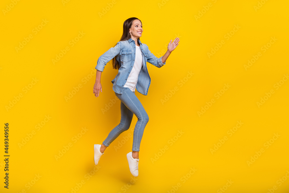 Full length profile photo of mature good lady run wear jeans shirt footwear isolated on yellow color background
