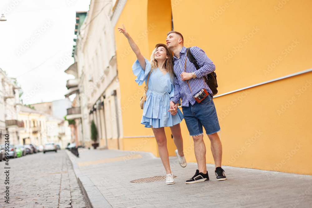 Young couple of tourists in love stroll along a European street