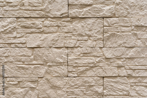 Photo of texture of stylish decorative beige brick wall background. Building, interior, room. Copy space